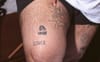 An image of a person's thigh showing multiple different tattoos, all inb
