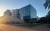 Modern glass academic building on a university campus at sunset, where students walk nearby. Related to Turning Point founder’s killing and concerns among LGBTQ+ students.